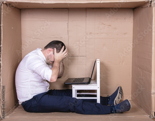 broken businessman in a cardboard office, stress and depression from overwork