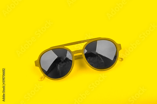 Gray modern fashionable sunglasses on yellow background. Trendy colors 2021 concept