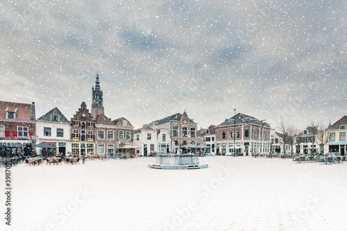 Snowfall on a winter day on the central square with ancient buildings in the Dutch city of Amersfoort, The Netherlands