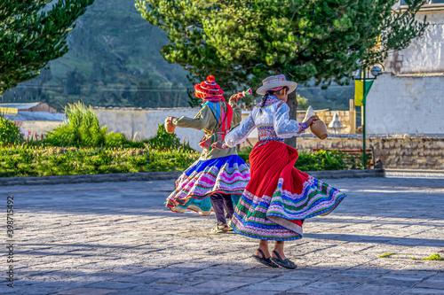 Peru, in the village of Chivay near the Colca Canon , joung girls dancing in traditional dresses around a fountain 