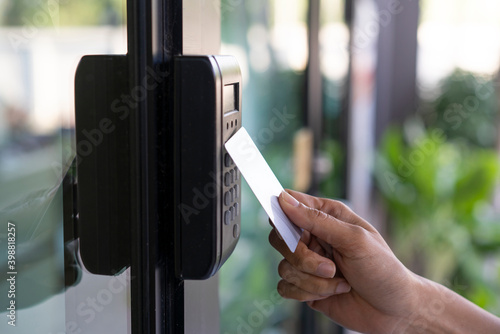 young woman using RFID tag key, fingerprint and access control to open the door in a office building