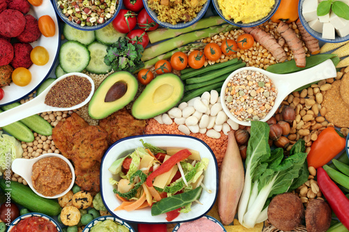 Vegan food for a healthy immune boosting diet with legumes, vegetables, nuts, dips, grains, snacks & cereal products. Plant based health foods for ethical eating & a healthy planet. Flat lay.