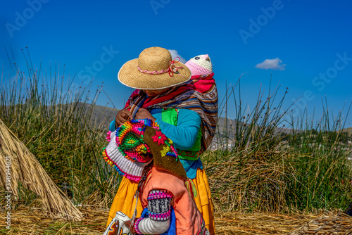 Peru, Lake Titicaca, Daily life of the URO people living on floating islands. Mother with kids.