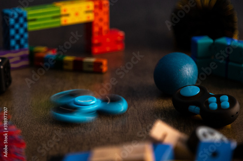 Spinning blue fidget spinner surrounded by other fidget toys for children. 