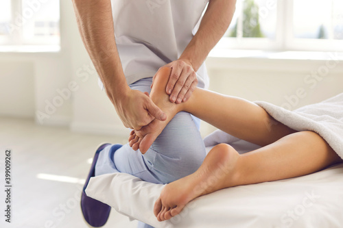 Cropped image of the hand of a male orthopedic doctor examining and massaging a patient's foot.