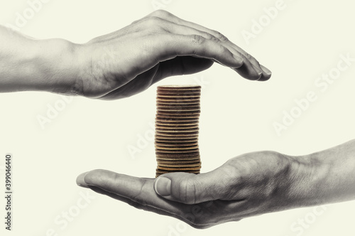 Stack of coin are protected by woman hands. Black and white. Concept safe custody of cash.