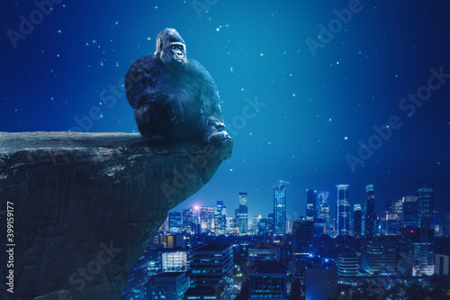 Gorilla sitting on cliff with glowing city background