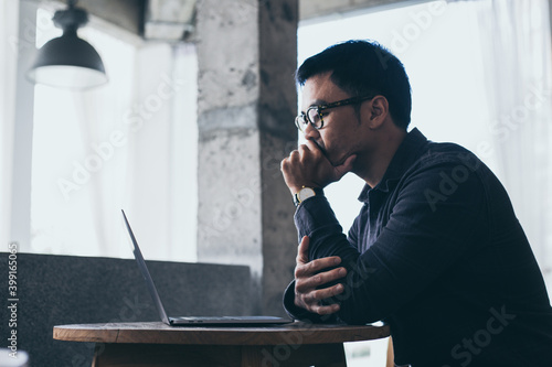 sad depression serious people from work stress concept.asian man feeling tired suffering using computer working work place.concept global economic and health problems