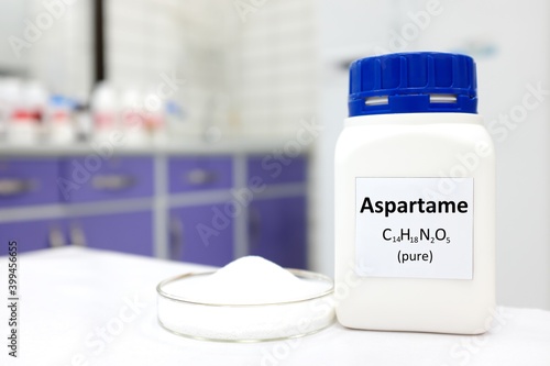 Selective focus of a bottle of pure aspartame artificial sweetener sugar substitute. White laboratory background with copy space.