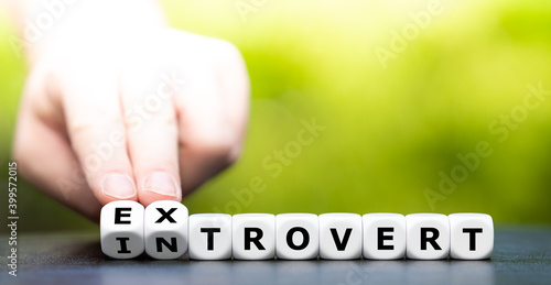 Hand turns dice and changes the word introvert to extrovert.