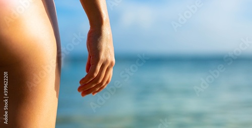 Woman standing on the beach in front of the ocean. Outdoor leisure.