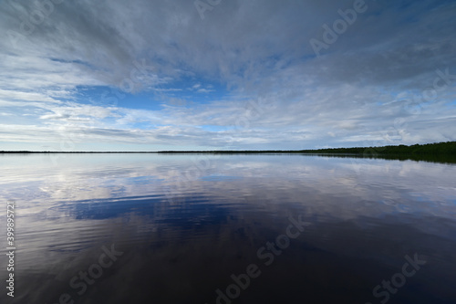 Winter cloudscape reflected in tranquil water of Coot Bay in Everglades National Park in late afternoon.