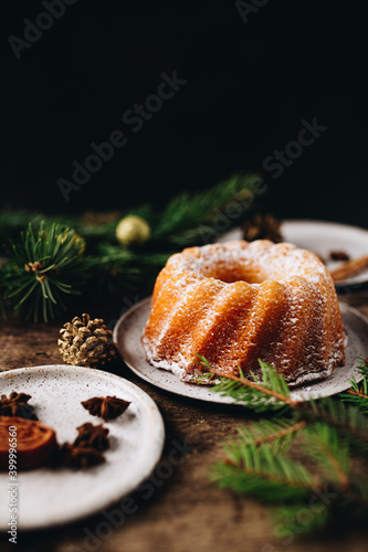 Guglhupf austrian cake with anise and cinnamon in a white plate with wood background. New year and christmas concept