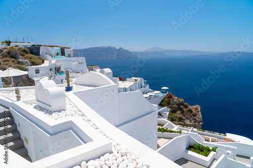 Balconies and roof tops in the village of Oia, Santorini. Architecture and landscape of Greece. Small cruze beside sthe shore.