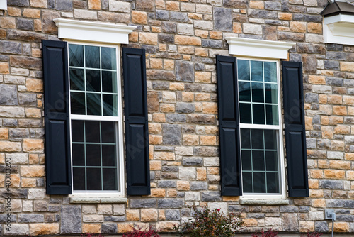 two pane vinyl window with shutters on a vinyl siding house new