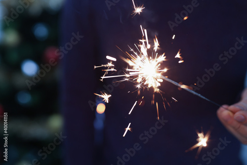 Man holding sparkler in hand for christmas closeup
