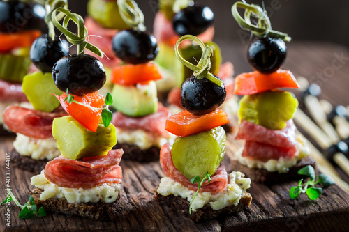 Various finger food made of meat, gherkins and olives