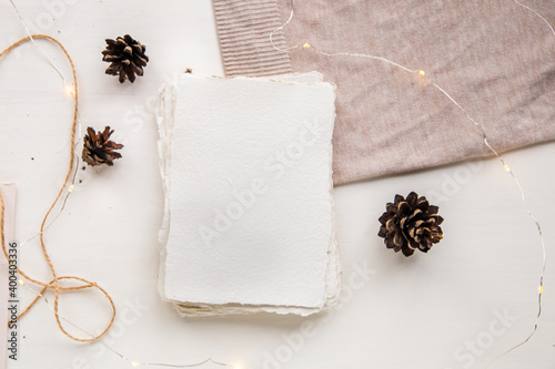 Hygge style flat lay. Christmas wish list. Handmade paper tied with craft thread. Letter mock up envelope, pine cones, craft thread.
