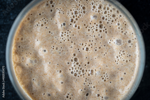 Glass jar with dough leaven. Preparing yeast dough for bread