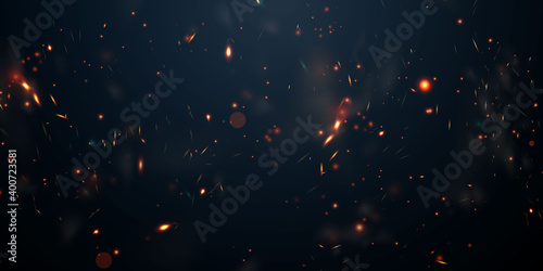 Sparks fly up Glowing particles on a black background and with flames