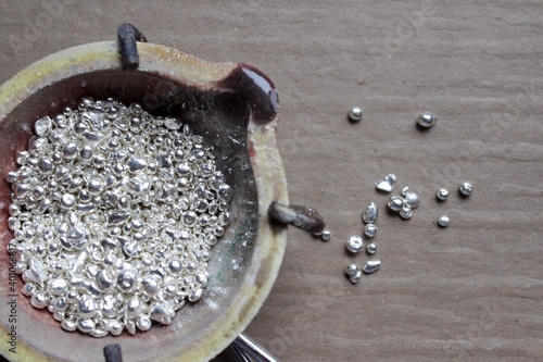 A ceramic crucible or melting pot with grains of sterling silver 925 for jewelry making after hand smelting in a workshop. One of the two major precious metals on the market.