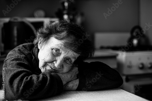 Portrait of old woman in her home. Black and white photo.