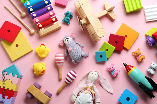 Different toys on pink background, flat lay