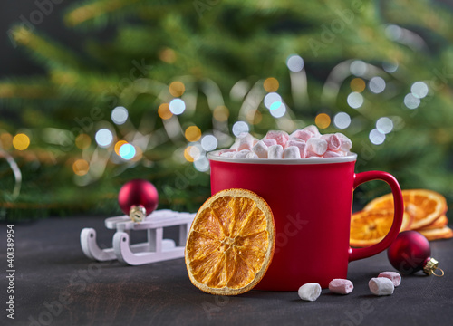Hot chocolate with marshmallows and dried candied orange in red cups for Christmas. Holiday concept. Selective focuse.