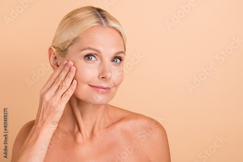 Photo of attractive perfect beauty aged lady nude shoulders touch cheek apply anti age cream isolated beige color background