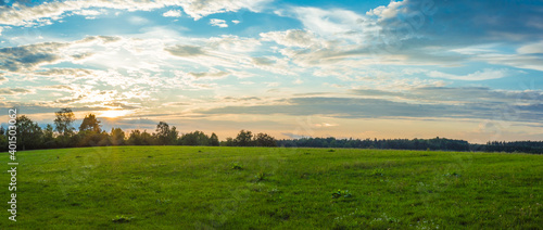 Landscape panorama. Sky with clouds. Green meadow. Gorgeous rural scene. Large open space.