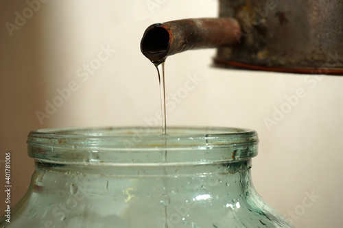 From the tube of the distillation cube flows into a jar of moonshine trickle.