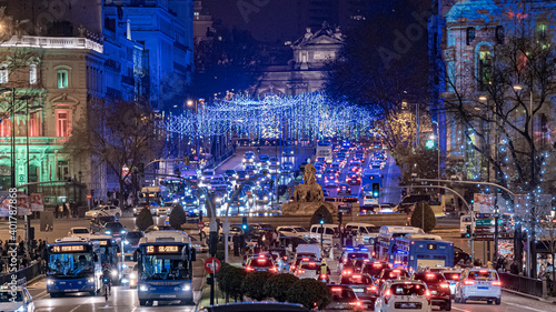 Estatua de la diosa Cibeles con vistas a la puerta de alcalá desde la calle Gran vía de Madrid, durante las navidades, con las luces azules y el tráfico del centro