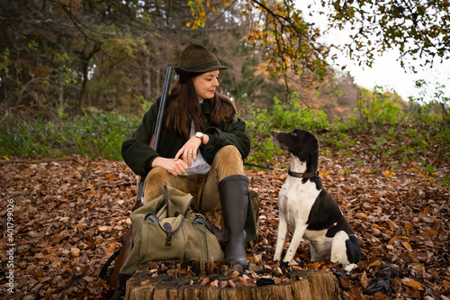 Jagd und Wildhege, junge Jägerin mit ihrem Jagdhund bei einem Reviergang, jagdliches Symbolfoto.