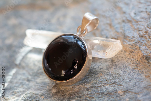 Sterling silver pendant with mineral onyx gemstone on rocky background