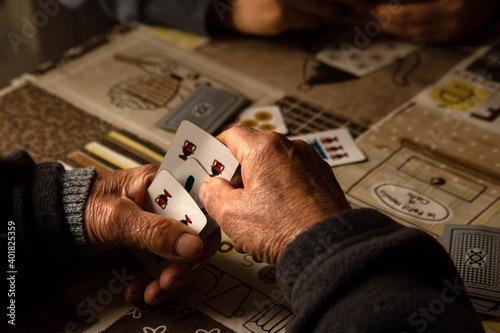 Persona anziana che gioca con le carte siciliane.