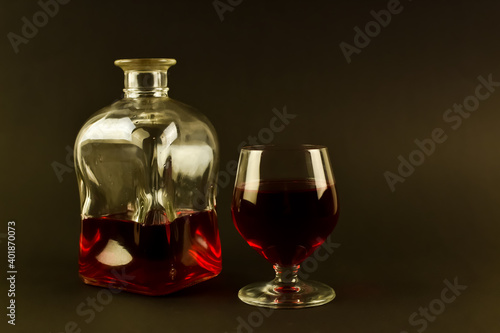 Kieliszek czerwonego wina i szklana karafka.