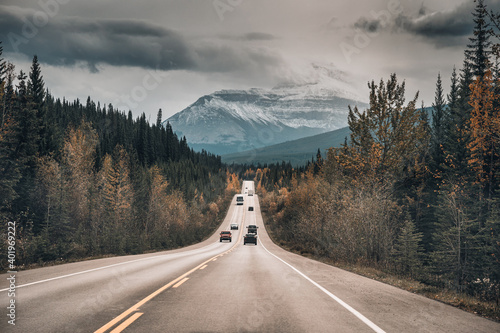Car driving on the road in autumn forest and rocky mountains in Jasper national park