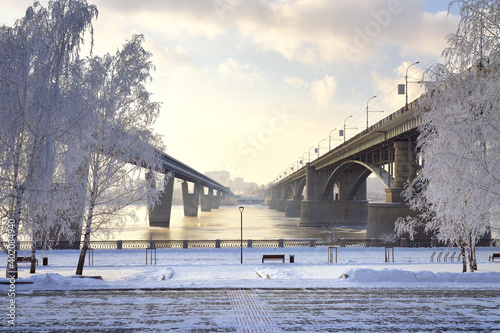 Michael's embankment in winter. Oktyabrsky bridge and metro bridge across the Ob lead to the Gorsky district