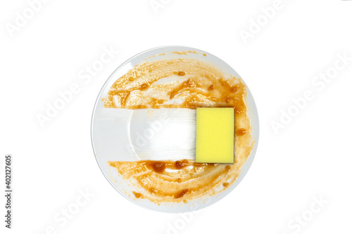 White round dirty plate with red sauce, yellow foam sponge cleaning dish top view , isolated on white background. Health and cleaning business concept