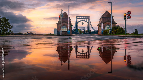 Die Kaiser-Wilhelm-Brücke in Wilhelmshaven mit Spiegelung in einer Regenpfütze.