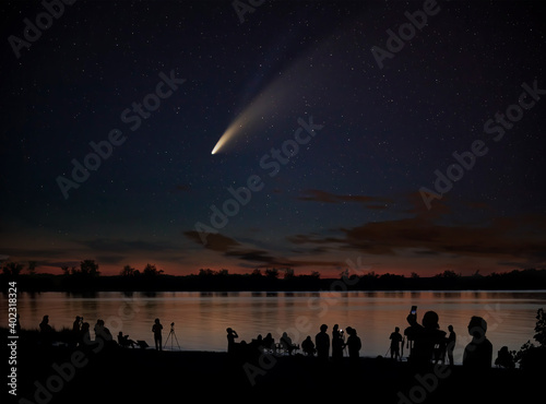 Comet Neowise comet C/2020 F3 (NEOWISE) and crowd of people silhouetted by the Ottawa river watching and photographing the comet