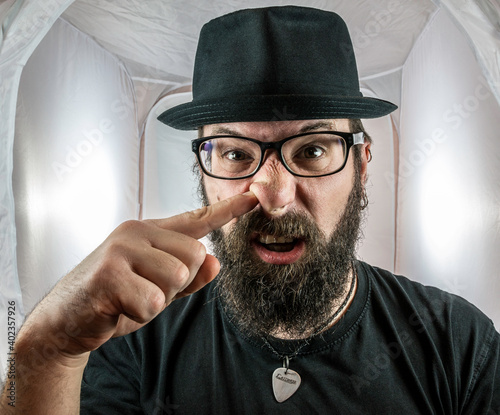 A silly looking bearded man with glasses and a black hat