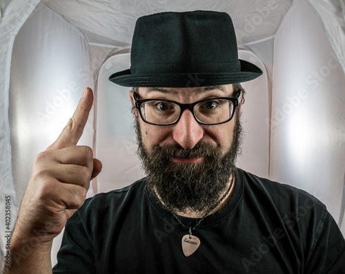 A bearded man with hat and glasses has an idea