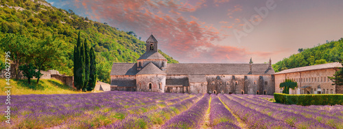 Notre-dame De Senanque Abbey, Vaucluse, France. Beautiful Landscape Lavender Field And An Ancient Monastery Abbaye Notre-dame De Senanque. Elevated View, Panorama. Altered Sunset Sky