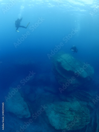 scuba diver underwater with rocks discovering reefs ocean scenery human