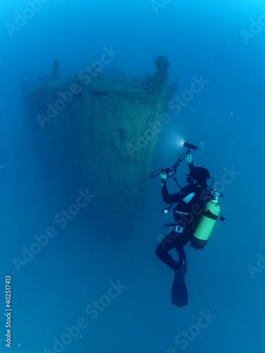 scuba divers exploring shipwreck scenery underwater ship wreck deep blue water ocean scenery of metal underwater