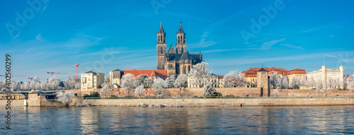 Panoramic view over Magdeburg historical downtown in Winter with icy trees and blue sky at sunny day, Germany.