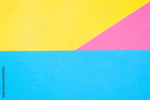 Multicolored paper background. Yellow pink and blue geometric backdrop. Three colors, copy space