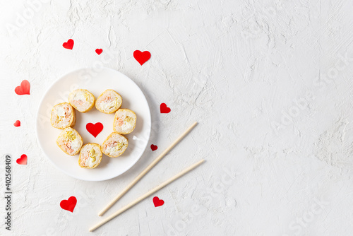 Sushi with red hearts on a white plate. Valentine's Day. Horizontal orientation, copy space.