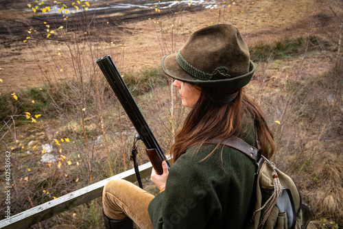 Jagd und Wildhege, junge Jägerin mit Flinte auf dem Reviergang - jagdliches Symbolfoto.